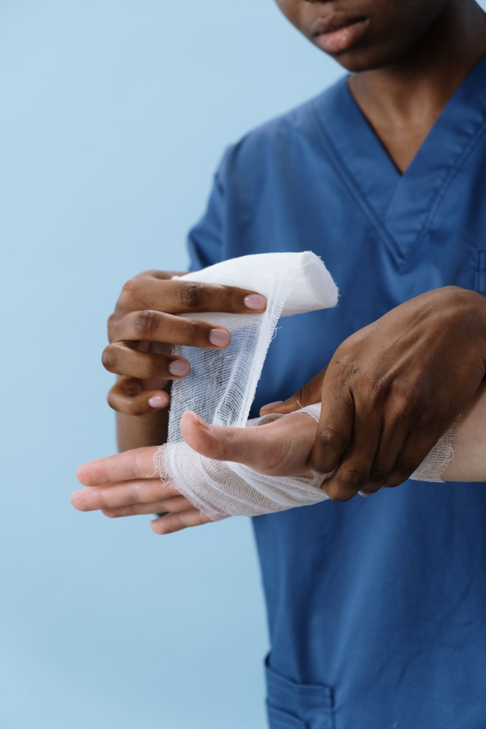 A nurse wrapping a clean gauze bandage around a patient's hand.