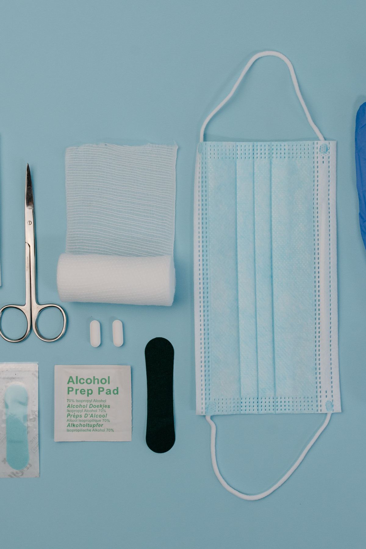 A full dressing kit laid out: gauze, scissors, forceps, alcohol prep pads, a mask and gloves.